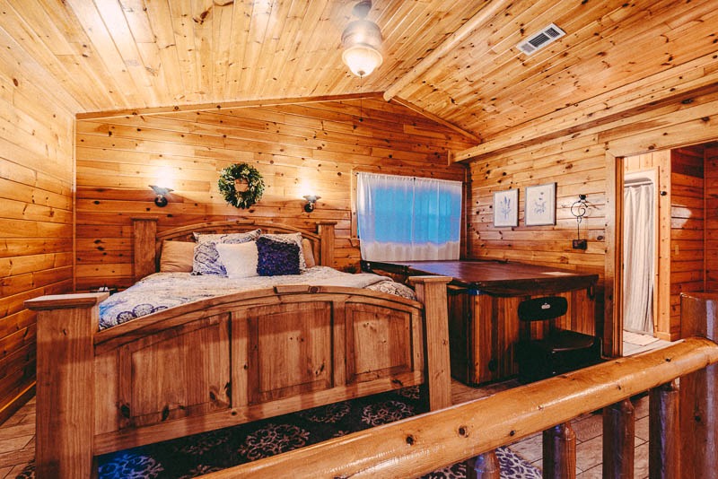 inside cabin view of king size bed and hot tub and bathroom